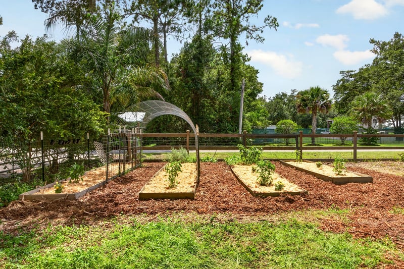 Garden beds with arbor and trees at 1161 Whispering Pines Rd, Jacksonville, FL 32259