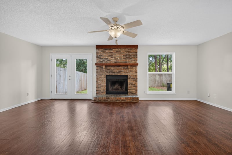 Living room with fireplace, ceiling fan and wood floors at 4427 Millstone Ct, Jacksonville, FL