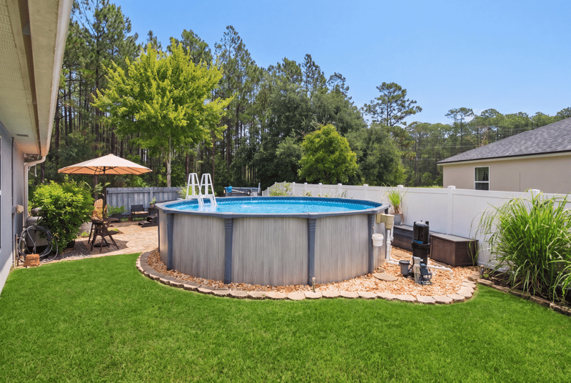 Backyard with above-ground pool and umbrella at 10923 Black Diamond Ct, Jacksonville, FL