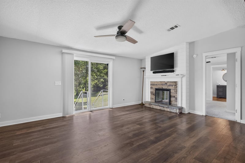 Living room with stone fireplace and wall-mounted TV at 4890 McAllister Rd, Middleburg, FL 32068