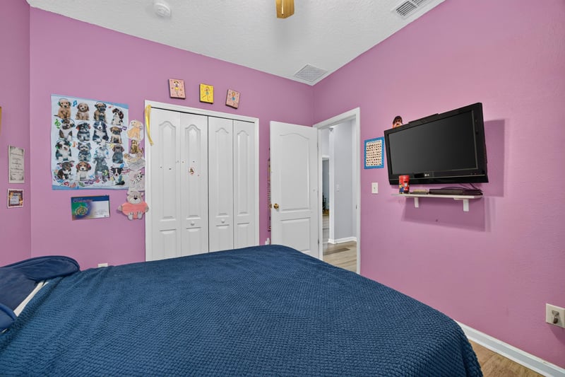 Bedroom with pink walls and wall decor at 2065 Creekmont Dr