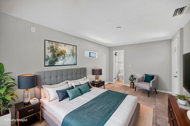 Virtually staged bedroom with bed, nightstands and armchair at 7453 Jade Dr N, Jacksonville, FL 32210