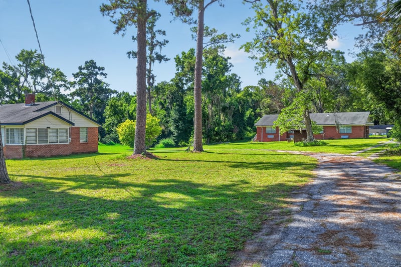 Backyard with open lawn and driveway at 5745 110th St, Jacksonville, FL 32244