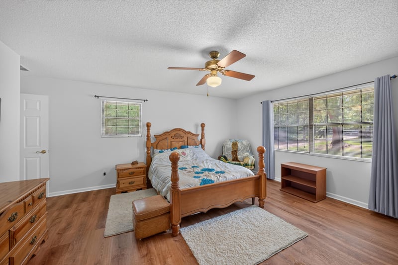Bedroom with two windows and wood flooring at 2435 Range Line Rd, Middleburg, FL
