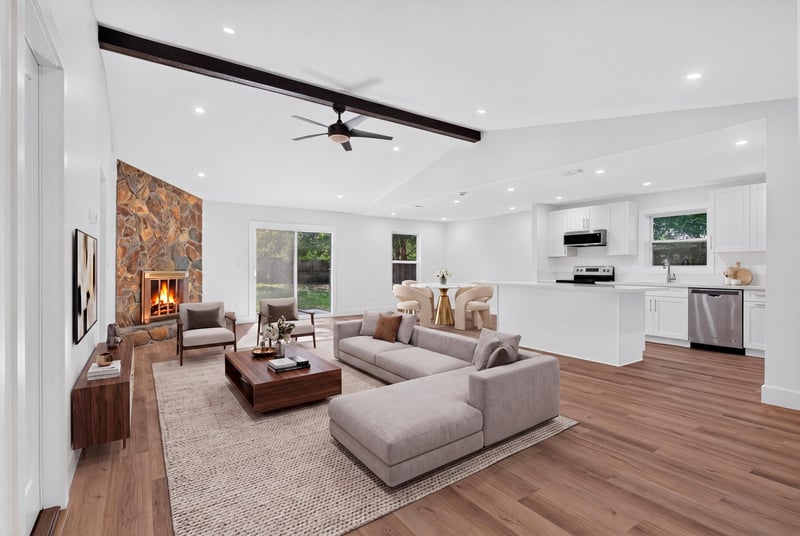 Living room with stone fireplace, vaulted ceiling, and staged sofa at 8453 Boysenberry Ln W, Jacksonville, FL