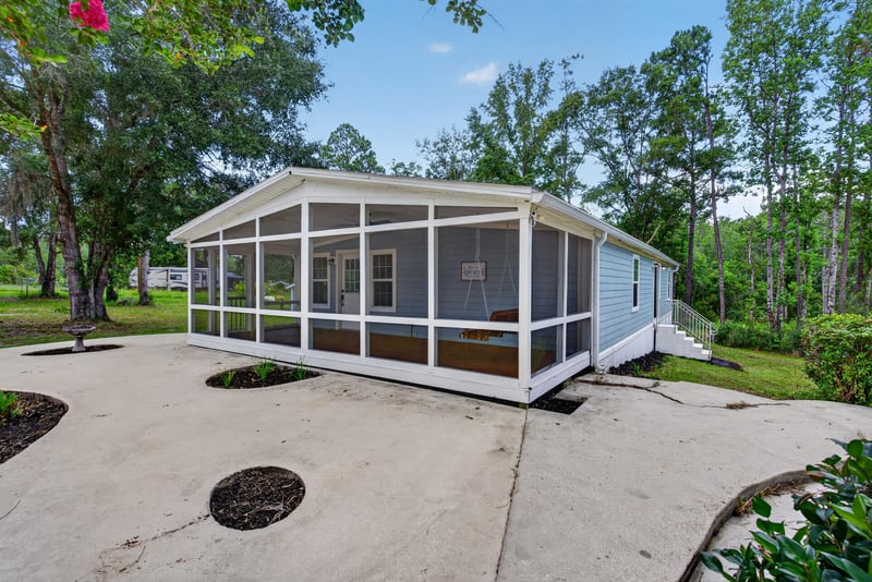 Aerial front view of home with screened porch and patio at 4890 McAllister Rd, Middleburg, FL 32068