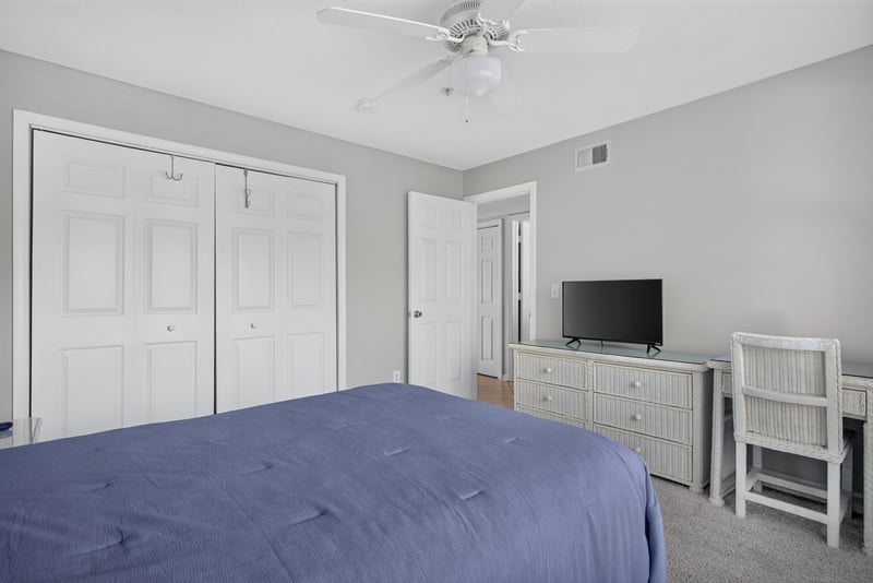 Second bedroom with bed, dresser and closet doors at 206 16th St, St. Augustine, FL 32080