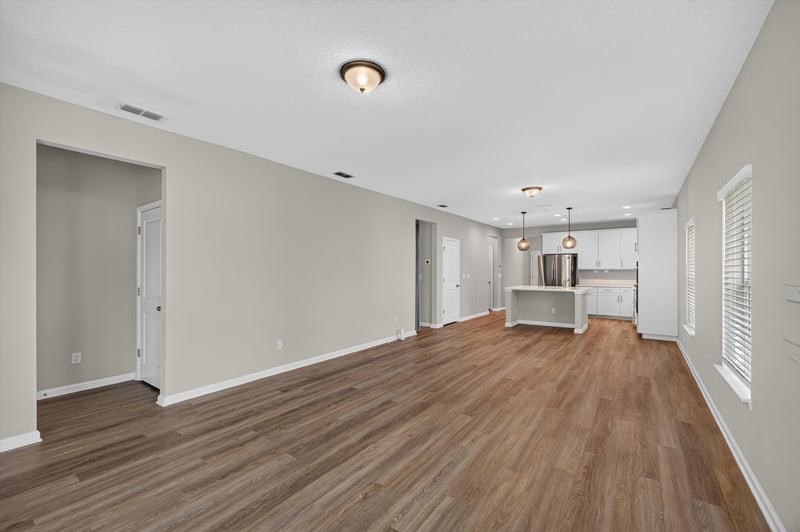 Open living and kitchen area with wood floor at 75875 Saffron Ln, Yulee, FL 32097
