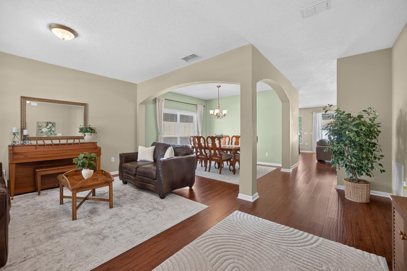 Living room with wood floors opening to a formal dining area at 3660 Middlebrook Dr, Orange Park, FL 32065