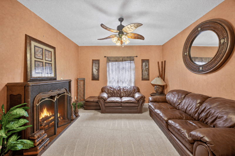 Living room with fireplace and leather sofas at 2875 Pebblewood Ln, Orange Park, FL 32065