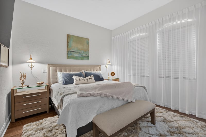 Bedroom with neutral bedding and bench at 140 Ave De La Mer, Palm Coast, FL 32137