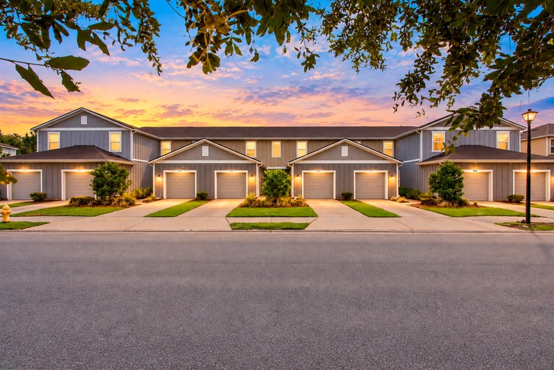 Day-to-dusk front view of the row of attached townhomes at 9555 Star Dr, Jacksonville, FL 32256