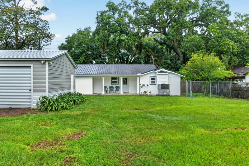 Side yard with detached garage and open lawn at 1619 Hammond Blvd, Jacksonville, FL