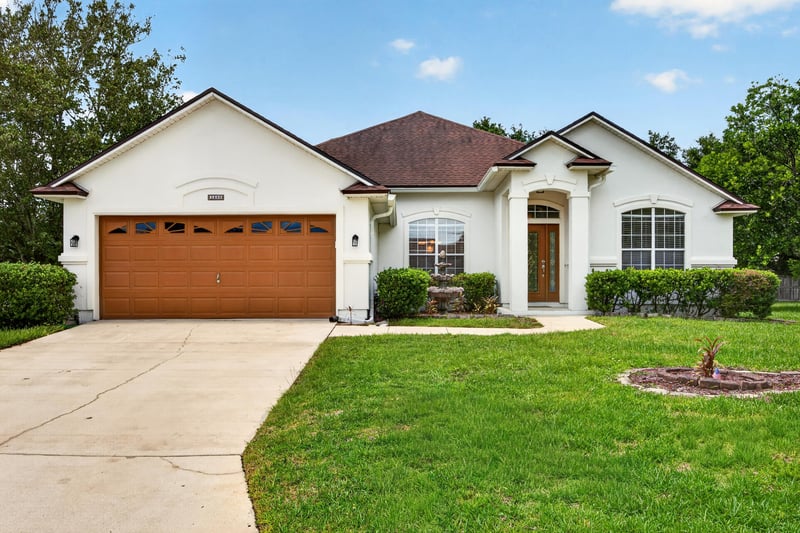 Front exterior with tile roof and two-car garage at 2480 Ridge Will Dr, Jacksonville, FL 32246