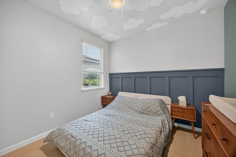Secondary bedroom with blue accent wall and dresser at 93 Lochloosa Ct, St. Johns, FL 32259