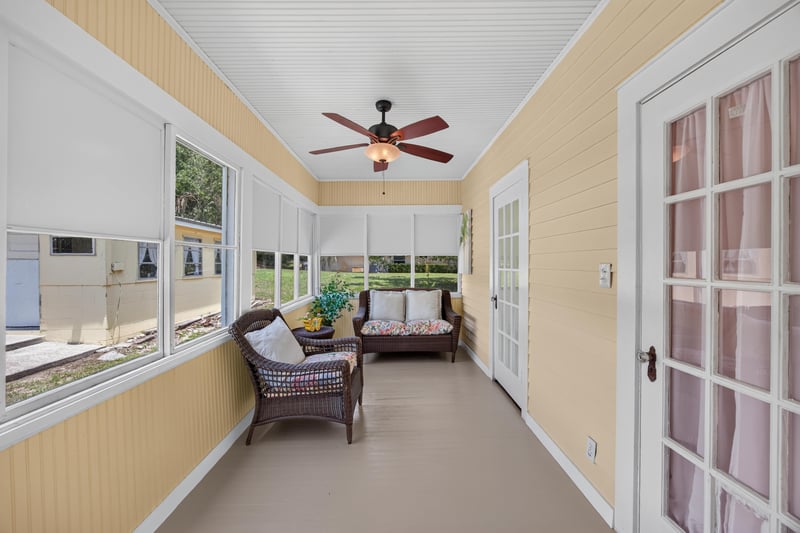 Sunroom with wicker furniture and ceiling fan at 101 N Lake St, Crescent City, FL