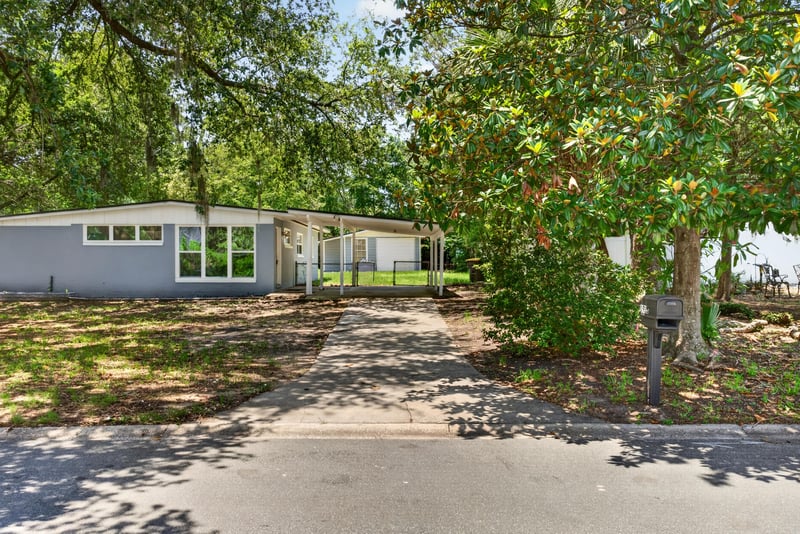 Front exterior seen through oak trees at 1928 Montmarte Dr, Jacksonville, FL 32210