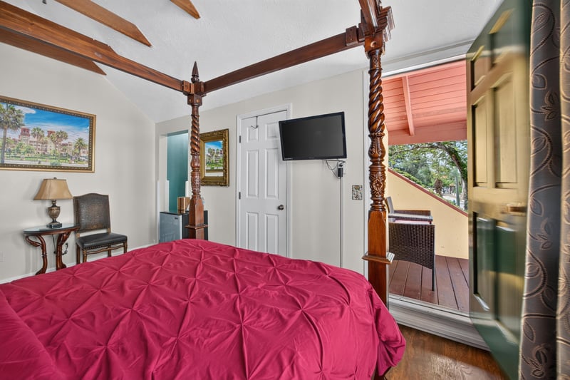Bedroom with a four-poster bed and wall-mounted TV at 115 Cordova St, St. Augustine, FL