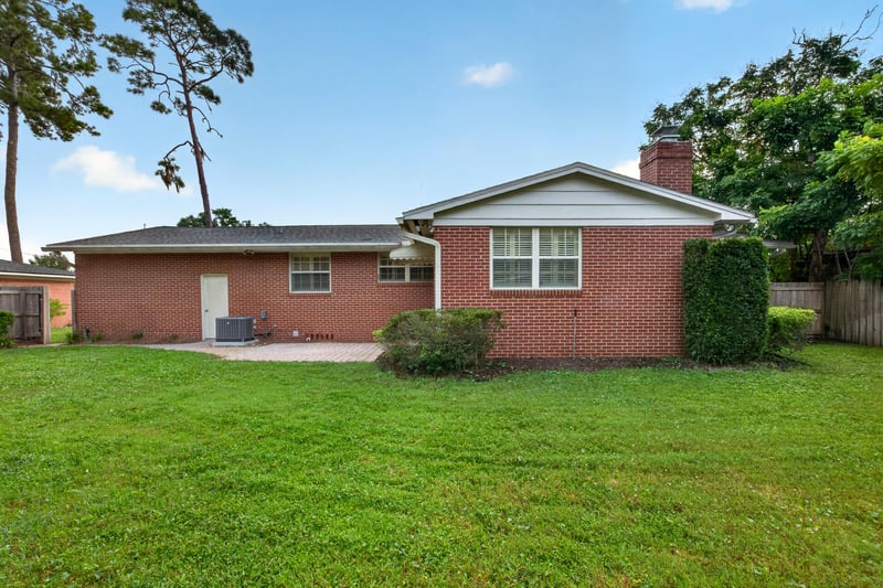 Backyard view of brick home exterior with paver patio at 1834 Memory Ln, Jacksonville, FL