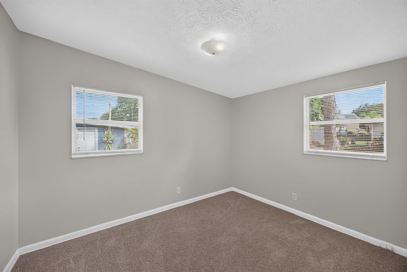 Carpeted bedroom with two windows at 87 Saratoga Cir S, Atlantic Beach, FL