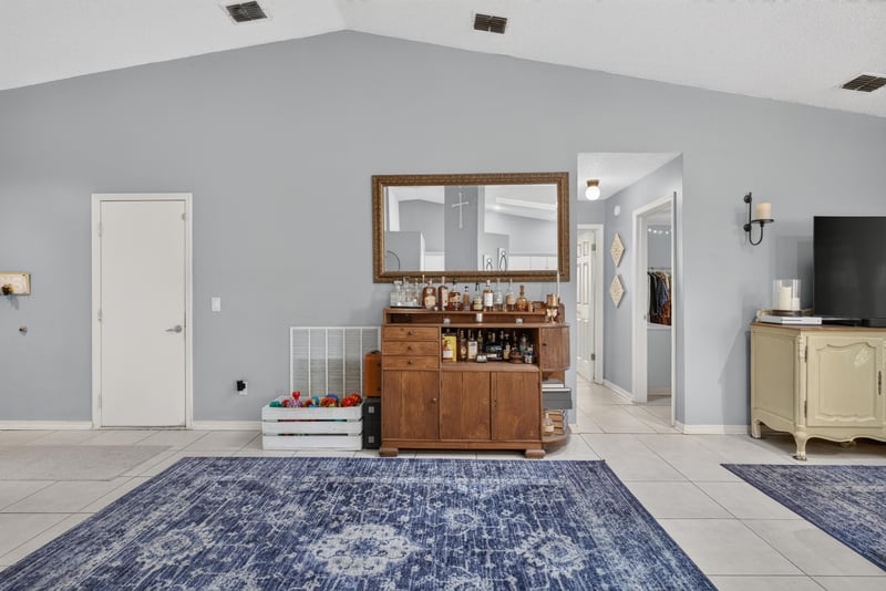 Living room with blue area rug and bar cabinet at 13020 Medford Ln, Jacksonville, FL 32225