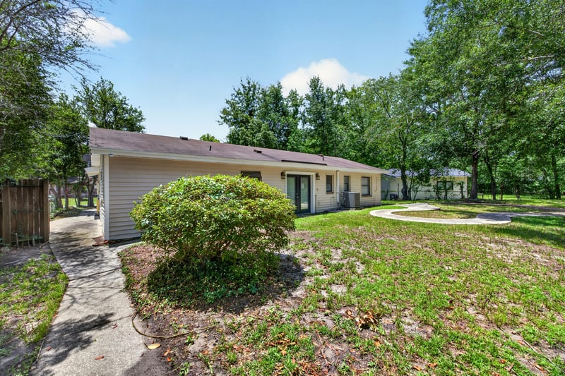Side yard view with curved walkway and landscaping at 7453 Jade Dr N, Jacksonville, FL 32210