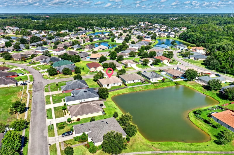 Aerial view of the street with pond and distant pool at 7545 Lirope St, Jacksonville, FL 32244