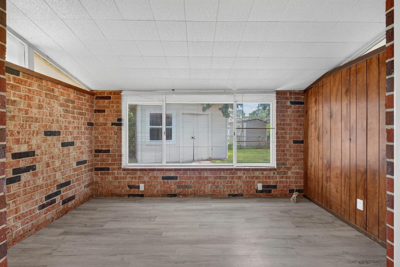 Den with brick wall and wood paneling at 5503 Boeing Dr, Jacksonville, FL 32207