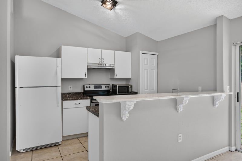 Kitchen with white refrigerator and breakfast bar at 7329 Lawn Tennis Ln, Jacksonville, FL
