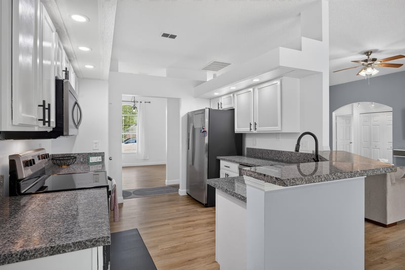 Kitchen island with granite counters and pendant lights at 8921 Needlepoint Pl, Jacksonville, FL 32244