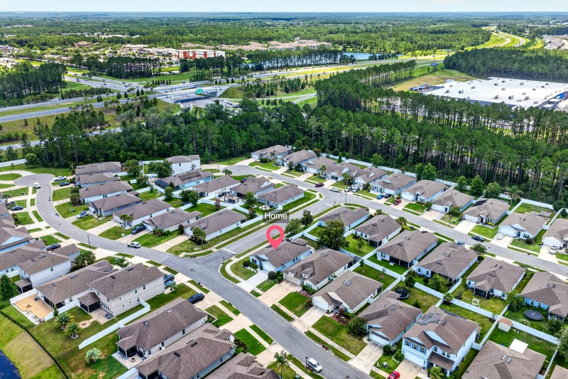Aerial view of the neighborhood and surrounding tree line in Jacksonville, FL