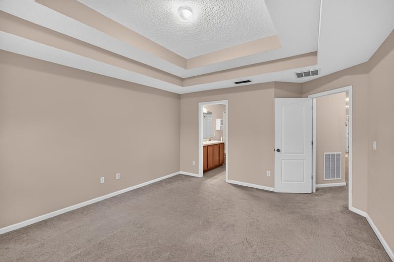 Bedroom with tray ceiling and closet doors at 3762 Hartsfield Forest Cir, Jacksonville, FL 32277