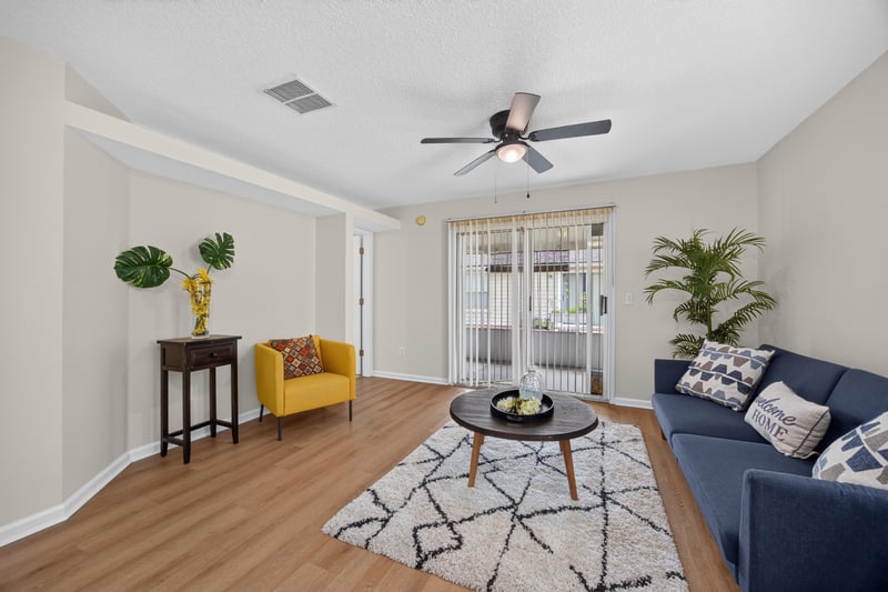 Living room with blue sofa and ceiling fan at 605 N Covered Bridge Rd, Jacksonville, FL
