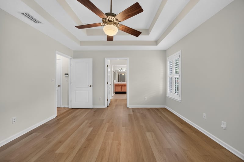 Bedroom with tray ceiling leading to hallway at 2131 E Stone Creek Dr, Fleming Island, FL