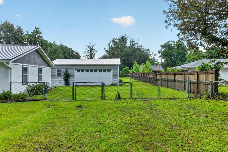 Side yard with wood fence and open grass at 1619 Hammond Blvd, Jacksonville, FL