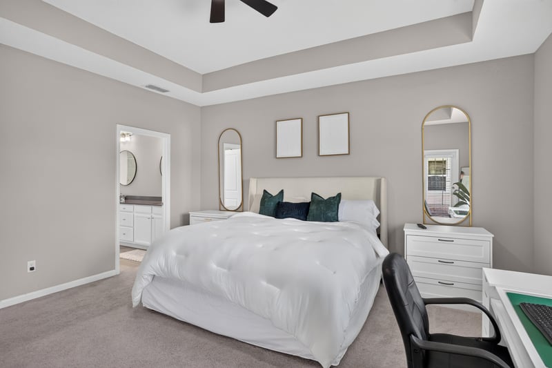 Primary bedroom with tray ceiling and dresser at 9942 Lovage Ln, Jacksonville, FL 32219