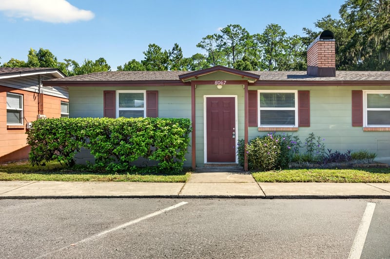 Front exterior with brick chimney and covered entry at 8067 Parental Cir, Jacksonville, FL 32216
