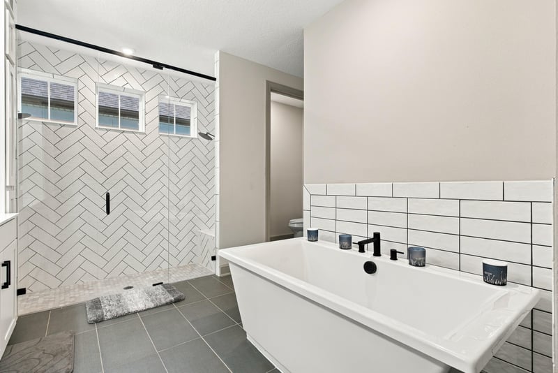 Primary bathroom tiled shower with herringbone pattern at 3921 Spyglass Hill Ln