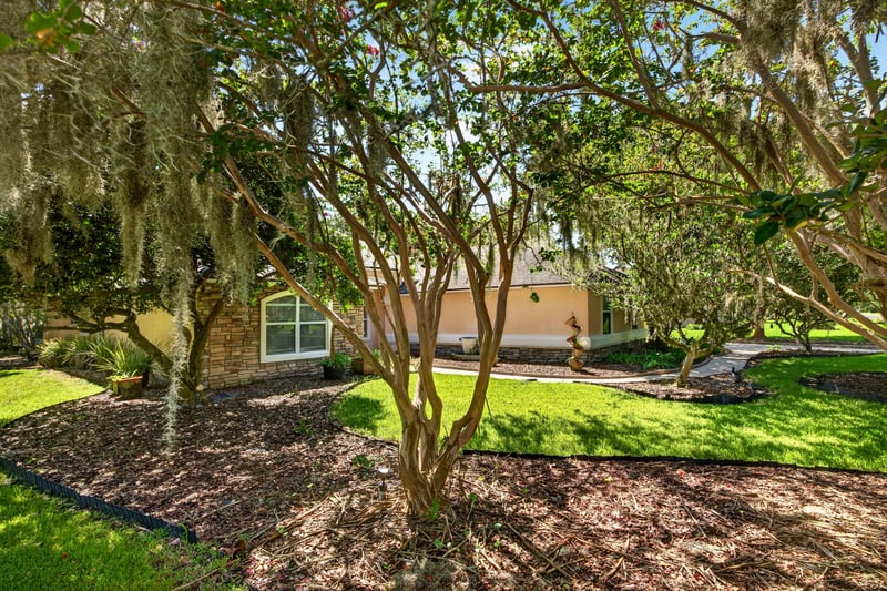 Front yard with mature trees and landscaping at 11675 Magnolia Estates Rd, Jacksonville, FL 32223