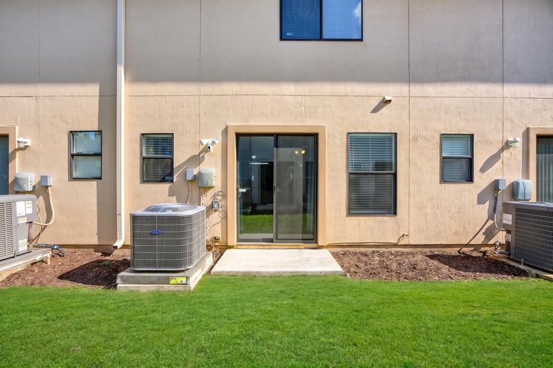 Rear patio and yard with AC units at 7723 Playschool Ln, Jacksonville, FL