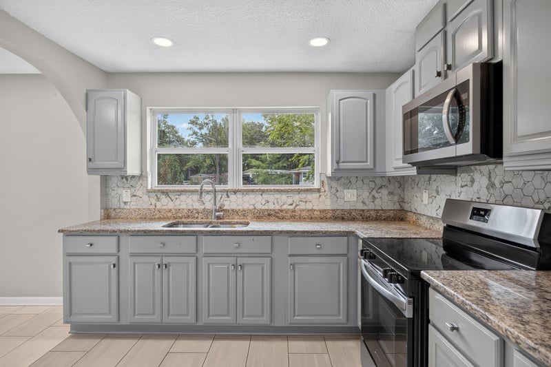 Kitchen with microwave and tile backsplash at 7015 Miss Muffet Ln N, Jacksonville, FL 32210