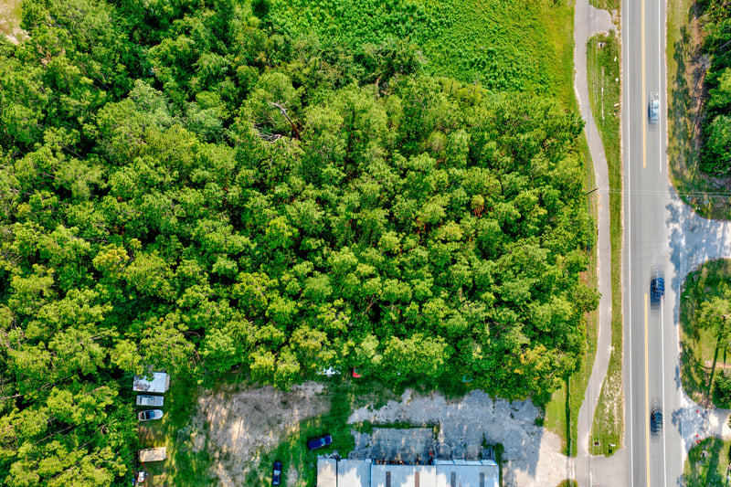 Aerial of the wooded lot along Co Rd 218 with nearby structures at 4393 Co Rd 218, Middleburg, FL 32068