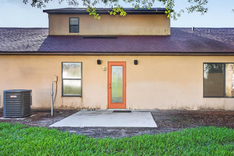 Rear patio with AC units and orange door at 353 Redwood Ln