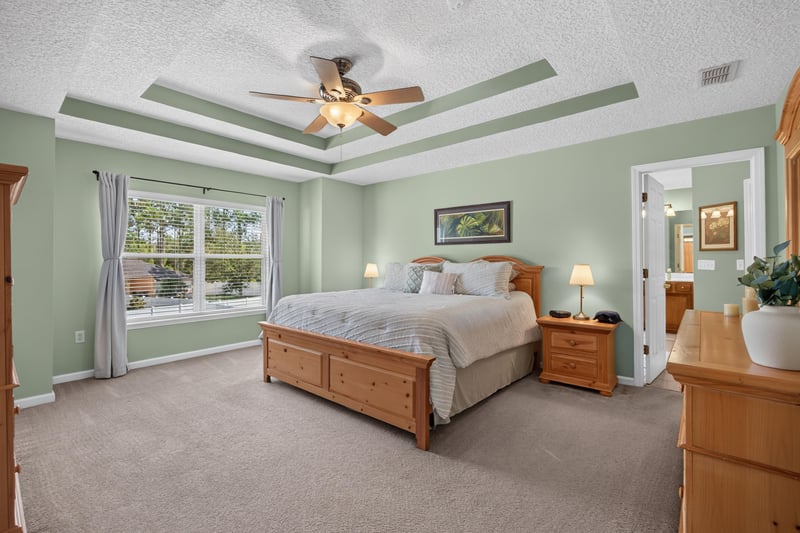 Primary bedroom with tray ceiling and large window at 3660 Middlebrook Dr, Orange Park, FL 32065