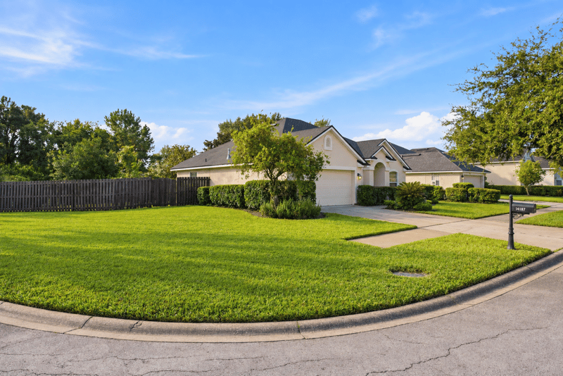 Front exterior with tile roof and landscaped lawn at 14187 Big Spring St, Jacksonville, FL 32258