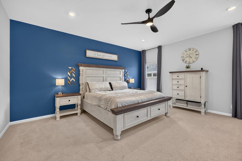 Primary bedroom with blue accent wall and ceiling fan at 2354 Jennings Farm Dr, Middleburg, FL 32068