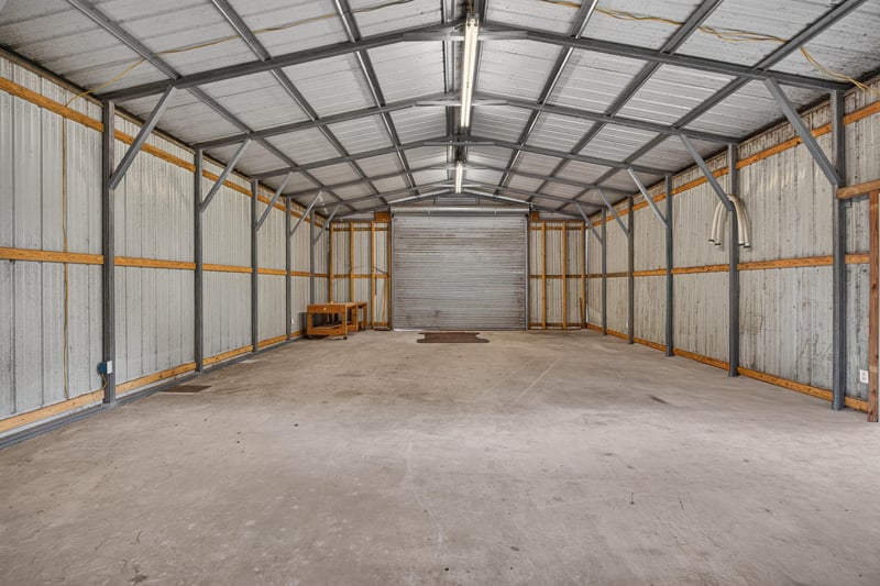 Interior of metal outbuilding showing depth and workbench at 5843 Ovella Rd, Jacksonville, FL 32244