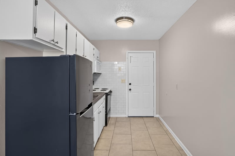 Kitchen with black refrigerator and white cabinets at 8067 Parental Cir, Jacksonville, FL 32216