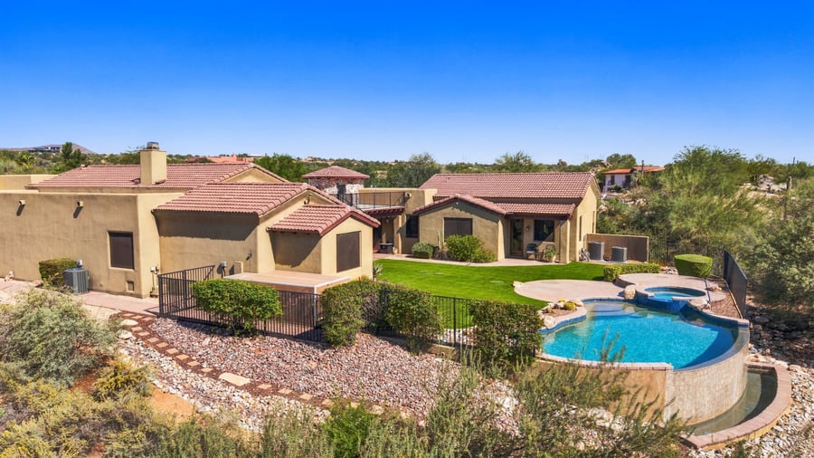 Aerial of a desert home with an infinity-edge pool