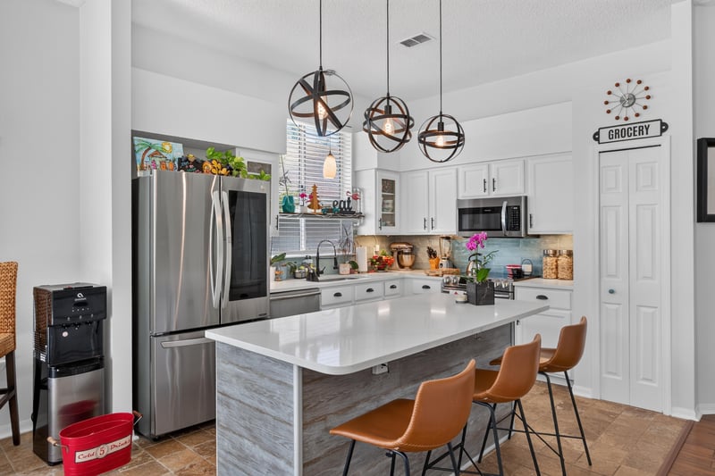 Kitchen with white cabinets and stainless refrigerator at 1820 Burgess Hill Dr E, Jacksonville, FL